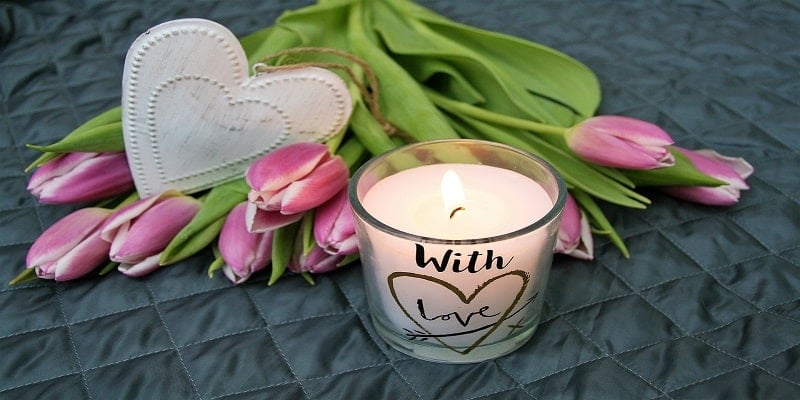 Memorial candle and pink tulips representing compassionate cremation services and remembrance