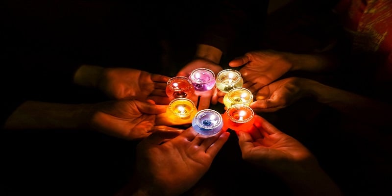 Hands holding memorial candles during a remembrance gathering for cremation services