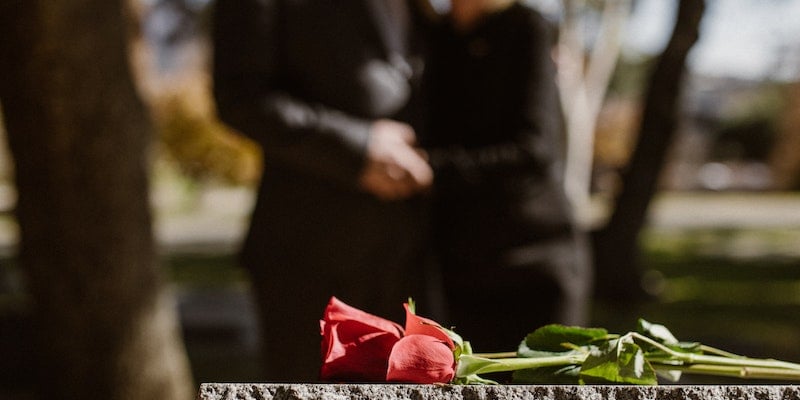 Red rose at a graveside during a memorial, reflecting compassionate cremation services and remembrance